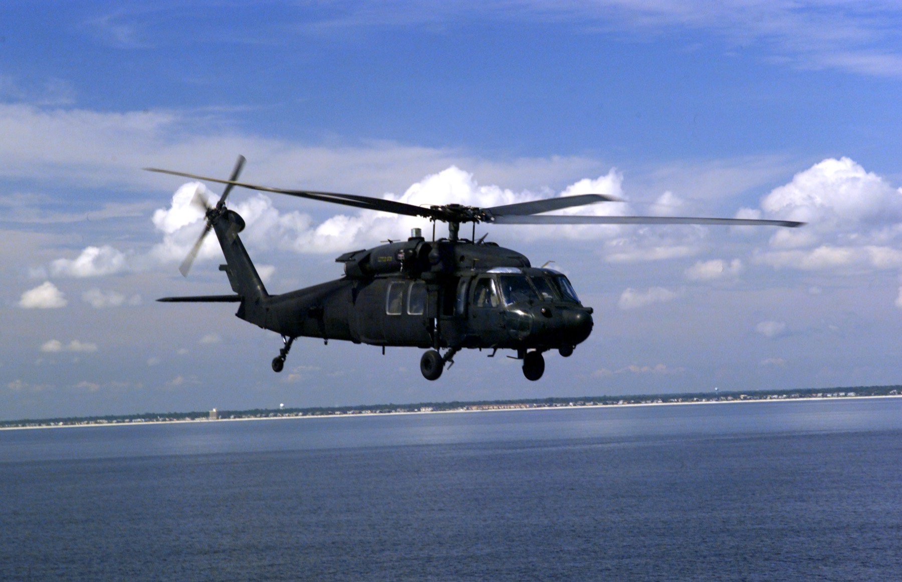 An MH-60L Black Hawk helicopter of the 160th Special Operations Aviation Regiment flying low over water.